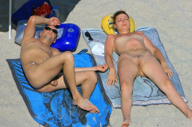 Naked men and women on a nudist beach