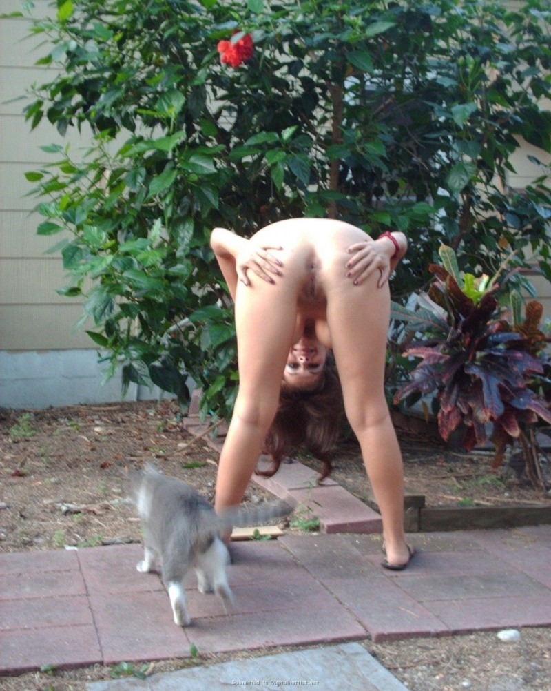 The girl undresses in the garden