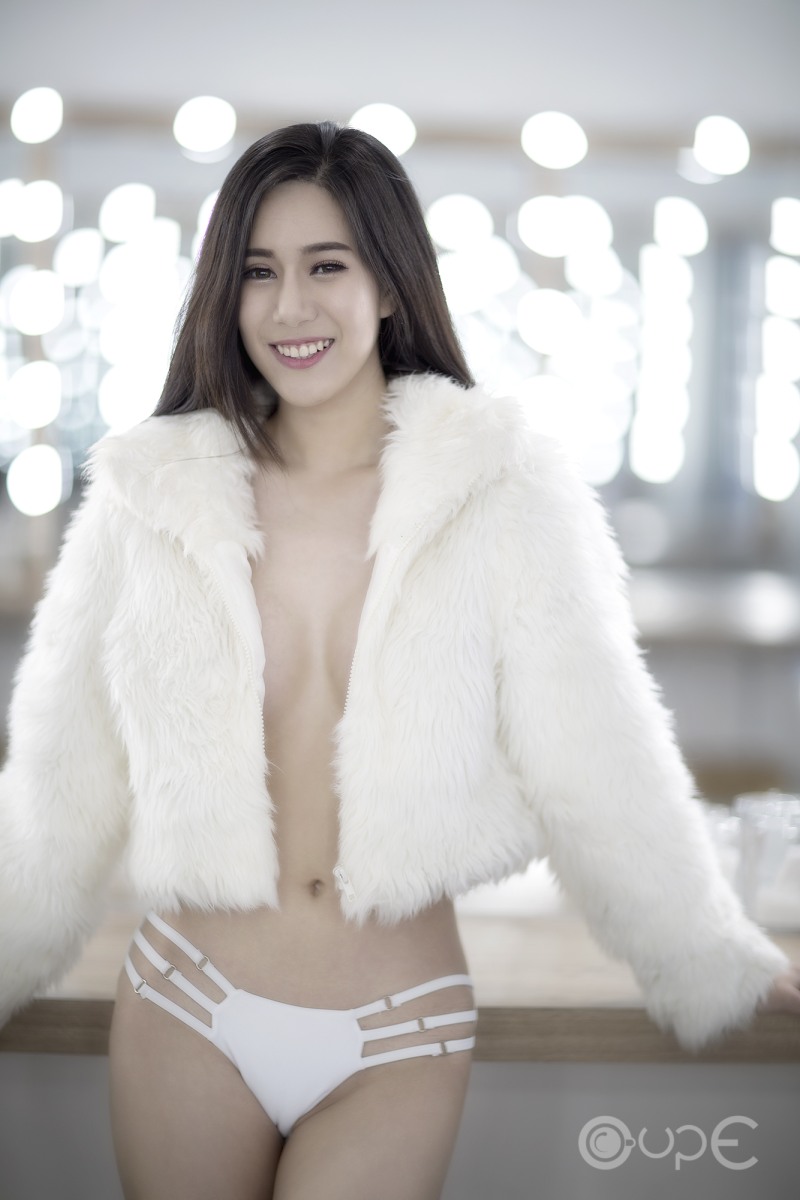 Adult woman in a fur coat on a naked body